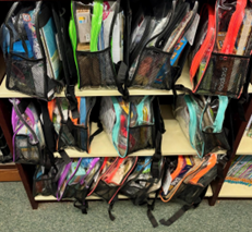 Backpacks lined up on a shelf