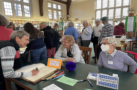 Photo of three white women gathered around a table with historic artifacts