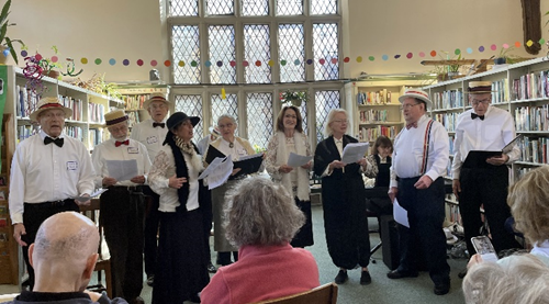 Photo of eight white men and women singing in period costume